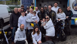 mark sewell getting on a motorbike as part of his fundraising effort